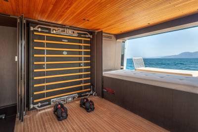 This luxurious yacht gym offers a serene workout space with stunning ocean views and adjustable dumbbells.