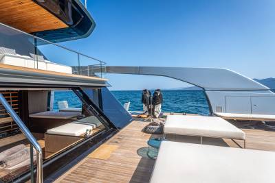 Relax on the spacious deck of this luxurious yacht, surrounded by the sparkling blue ocean and distant mountains.