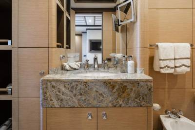 Luxurious wood paneling and marble create a serene and elegant bathroom sanctuary on this yacht.