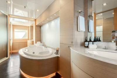 Luxurious yacht bathroom features a spacious jacuzzi and elegant vanity with chrome fixtures.