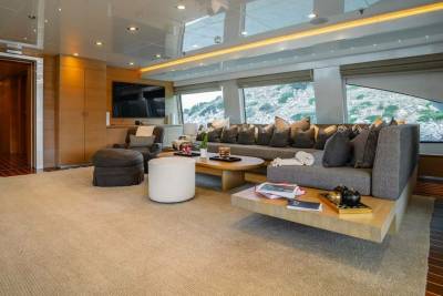 Luxurious yacht interiors offer a chic and comfortable lounge area with panoramic views of the rocky coastline.