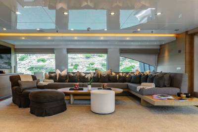 This luxurious yacht salon offers a serene escape with plush seating and stunning views of the rocky coastline.
