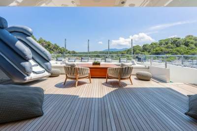An inflatable slide and comfortable seating create a playful and relaxing outdoor lounge area on this luxurious yacht.