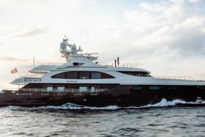 The luxurious yacht Zia glides through the choppy blue waters under a cloudy sky.
