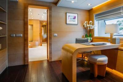 A sleek, modern office space with warm wood finishes and a large window overlooking a scenic view offers a tranquil work environment.