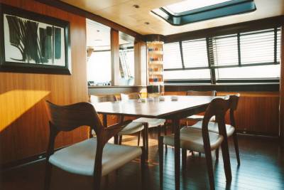 A warm dining room with wooden accents and a large table bathed in golden sunlight offers a cozy gathering space.