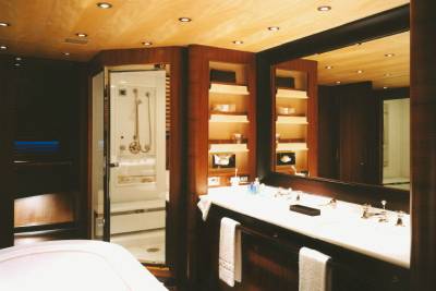 Luxurious wood paneling and a sleek glass shower define this opulent yacht bathroom.