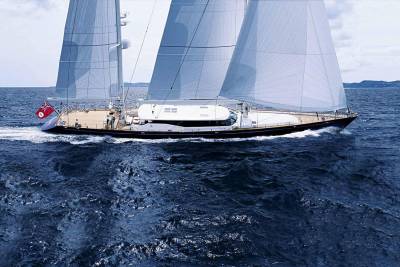 A majestic sailing yacht glides through the deep blue ocean under a cloudy sky.