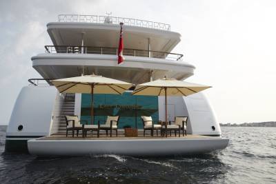 The luxurious Lady Christine yacht offers a serene deck with comfortable seating and umbrellas for a relaxing day at sea.