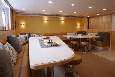 A cozy dining nook with plush seating and a large table offers a comfortable space for meals aboard this luxurious yacht.