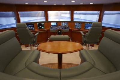 The bridge of a luxury yacht offers a commanding view of the water with comfortable seating and advanced navigation systems.