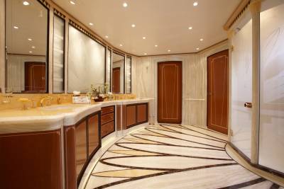 Luxurious marble floors and rich wood cabinetry create an opulent atmosphere in this yacht's elegant bathroom.