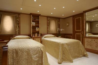 Luxurious twin beds draped in elegant patterned linens create a serene retreat in this opulent yacht cabin.