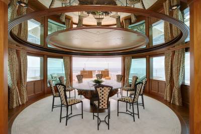 Dine in opulent style aboard this yacht, where a grand dining room offers panoramic ocean views through expansive windows.