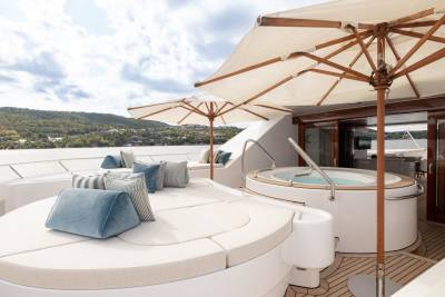 Relax in the hot tub or lounge on the sun deck of this luxurious yacht with a scenic backdrop.