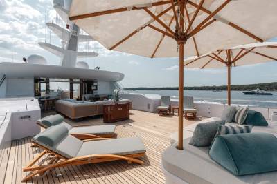 Luxurious sun loungers and plush seating invite relaxation on the expansive deck of this opulent yacht.