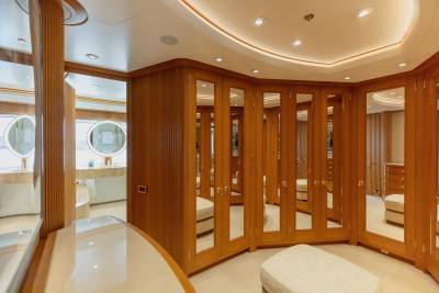 Luxurious wooden wardrobes with mirrored doors line this elegant yacht dressing room.