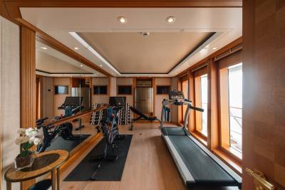 A well-equipped gym with treadmills, stationary bikes, and weights offers a luxurious workout space with ocean views.