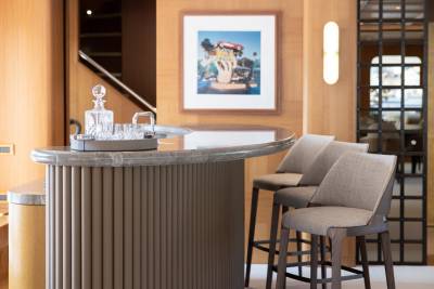 Luxurious bar stools and crystal decanter await guests in this elegantly appointed yacht lounge.