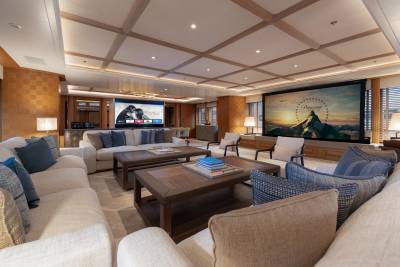 This luxurious yacht's cinema room offers plush seating and two large screens for an immersive viewing experience.