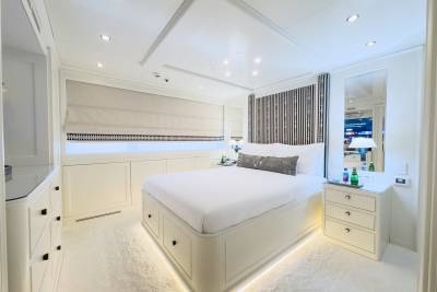Luxurious yacht cabin features a plush bed, modern lighting, and elegant cabinetry for ultimate comfort at sea.