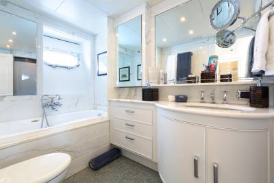 Luxurious marble and polished chrome define this elegant yacht bathroom, complete with a deep soaking tub and a spacious vanity.