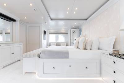 Luxurious white bedding and elegant furnishings create a serene master suite on this opulent yacht.