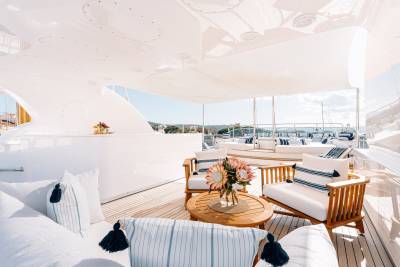 Luxurious outdoor seating on a yacht deck offers a serene spot to enjoy the Mediterranean coast.