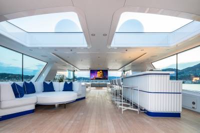 Relax on the spacious deck of this luxury yacht, complete with a bar and outdoor cinema, overlooking a picturesque coastal town.