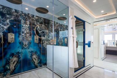 Luxurious marble floors and a striking blue-veined shower enclosure create a spa-like oasis.