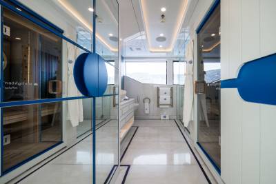 This modern spa area features a sleek design with glass-enclosed saunas and a luxurious bathroom overlooking a scenic landscape.