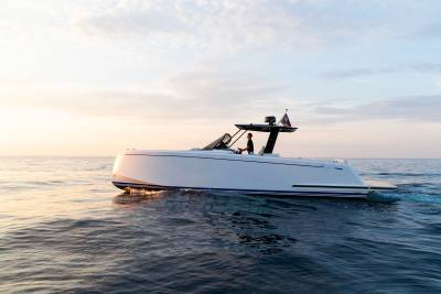 A sleek white yacht glides across calm waters under a soft, pastel sky at sunrise.