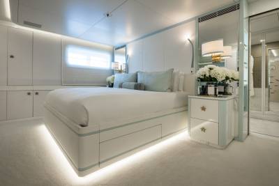 Serene luxury defines this master stateroom, featuring a plush bed, ambient lighting, and elegant mirrored cabinetry.