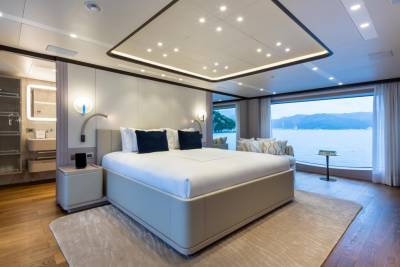 Luxurious yacht bedroom offers serene water views and a plush king-sized bed.