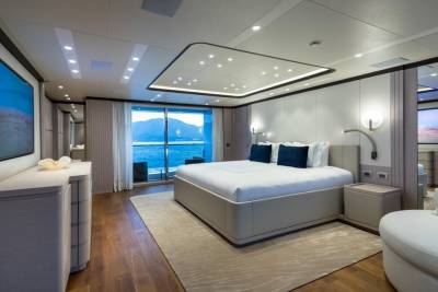 Luxurious yacht bedroom offers stunning ocean views and modern comfort with a king-sized bed and elegant decor.