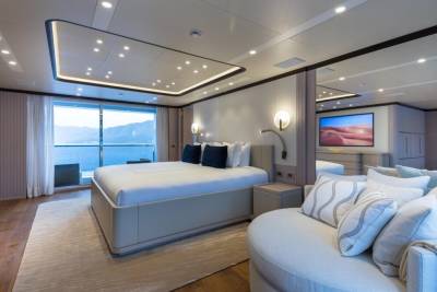 Luxurious yacht master suite offers stunning ocean views and modern comfort with a plush bed and elegant seating area.