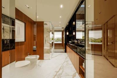 Luxurious marble and warm wood create a serene spa-like atmosphere in this modern bathroom with stunning water views.