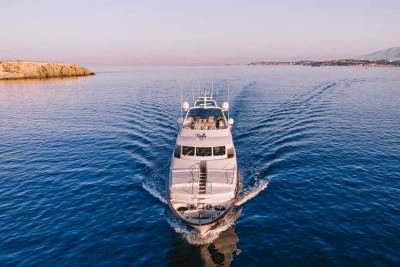A luxurious white yacht cuts through the deep blue sea, leaving a foamy wake under a soft twilight sky.