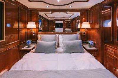 Luxurious wood paneling and plush bedding create an opulent sanctuary aboard this elegant yacht.