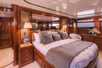 Luxurious wood finishes and plush bedding create an opulent master suite aboard this elegant yacht.