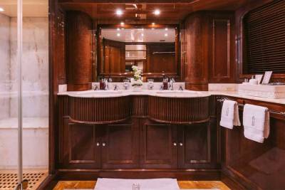 Luxurious dark wood cabinetry and marble accents create an opulent bathroom sanctuary on this yacht.