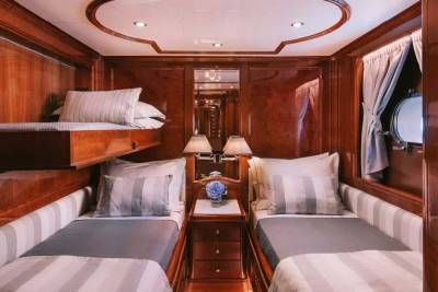 Luxurious wood paneling and plush bedding create a serene sleeping cabin aboard this elegant yacht.