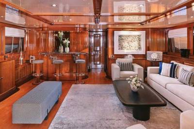 Luxurious wood paneling and plush seating create an inviting atmosphere aboard this elegant yacht.