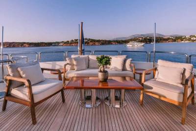 Relax on the deck of a luxurious yacht, enjoying the serene ocean views and coastal landscape.