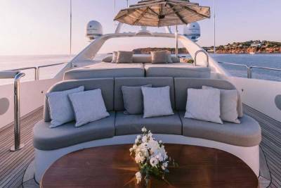 Relax on the plush seating of this luxurious yacht while enjoying a serene ocean sunset.