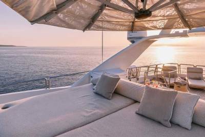 Relax on the plush sunbeds of this luxurious yacht as the sun sets over the tranquil ocean.