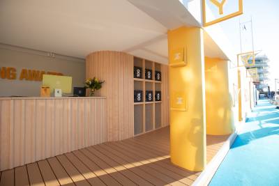 Bright yellow pillars and wooden accents create a welcoming reception area at this sunny outdoor event.