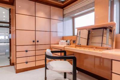 A spacious and well-designed home office with wooden cabinetry, a desk, and a comfortable chair, situated in a bright and modern interior.