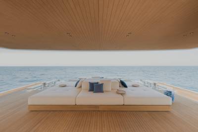 Relax on the spacious deck of a luxury yacht, surrounded by the serene blue ocean and a warm wooden ceiling.