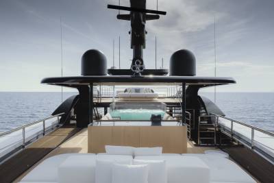 Luxurious yacht deck features a pristine pool and plush seating overlooking the tranquil ocean.